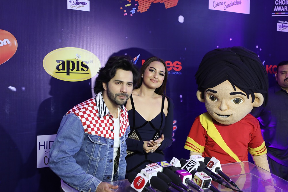 Varun and Sonakshi take a moment from the hustle to pose with Shiva on Orange carpet